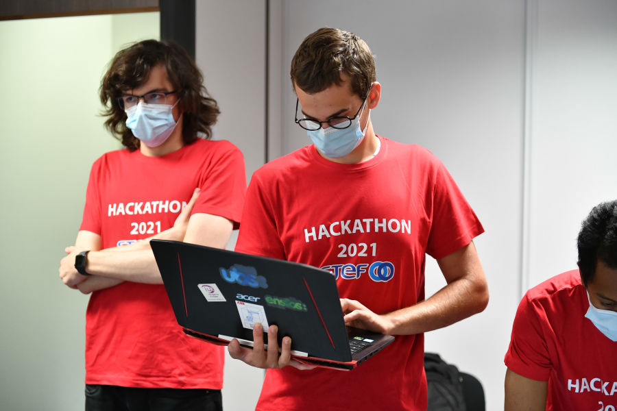 2 membres de l'equipe rouge celui de gauche les bras croises et celui de droite sur son ordinateur - Reportage HACKATHON- Carquefou (44)